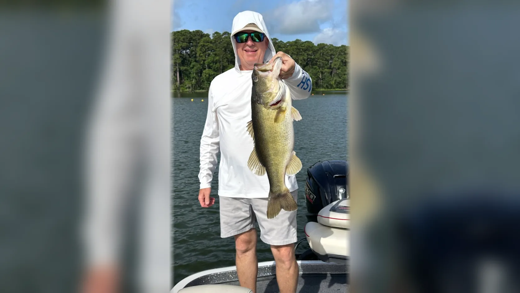 Tony holds a largemouth bass while standing on a fishing boat at Lake Conroe.