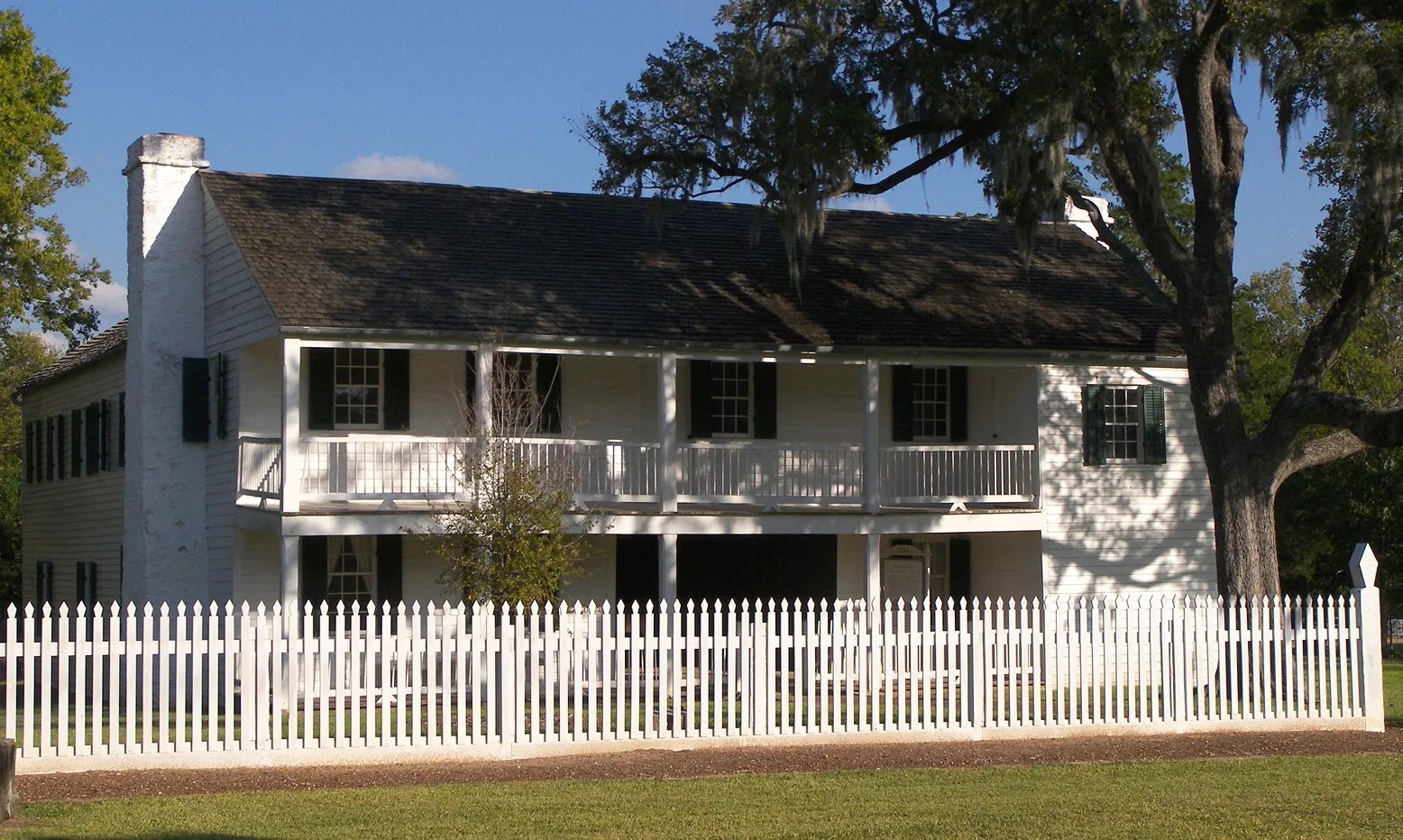 The two-story white Fanthorp Inn in Anderson, Texas, with a gallery, dark shutters, and a picket fence