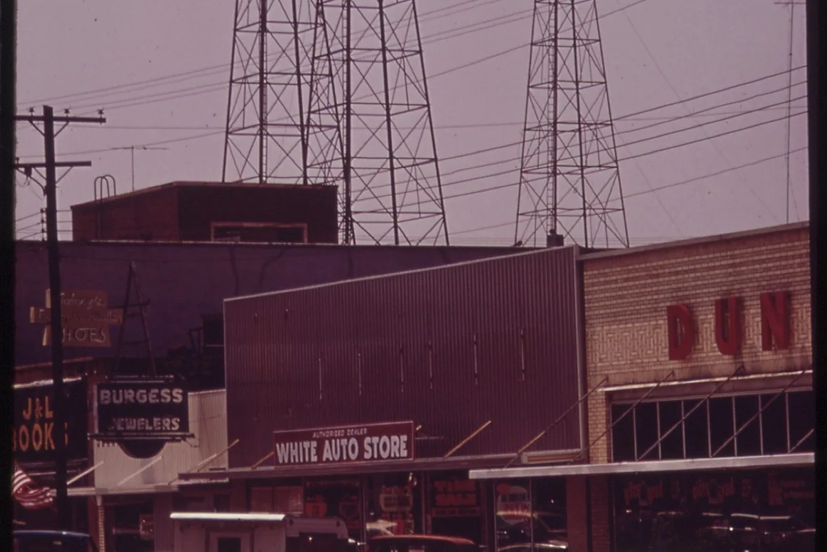 Steel oil derricks rising behind brick storefronts on Main Street in Kilgore, Texas, in 1972
