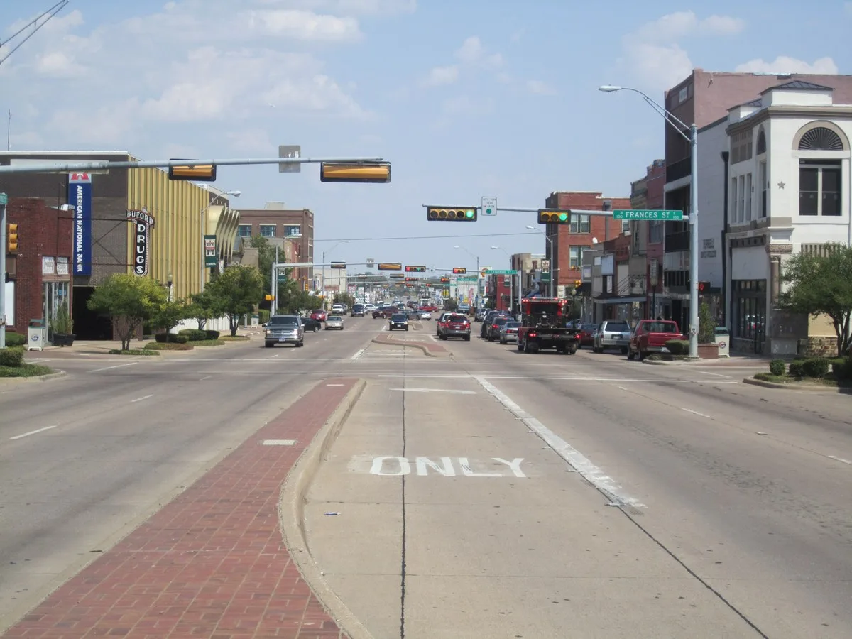 U.S. Highway 80 running through downtown Terrell with traffic signals, a brick median and storefronts