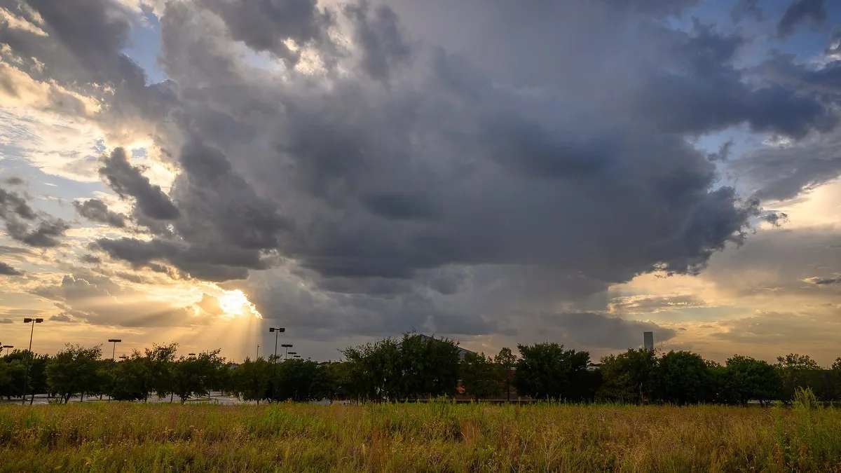 Storm clouds and a setting sun over a grassy field in Flower Mound